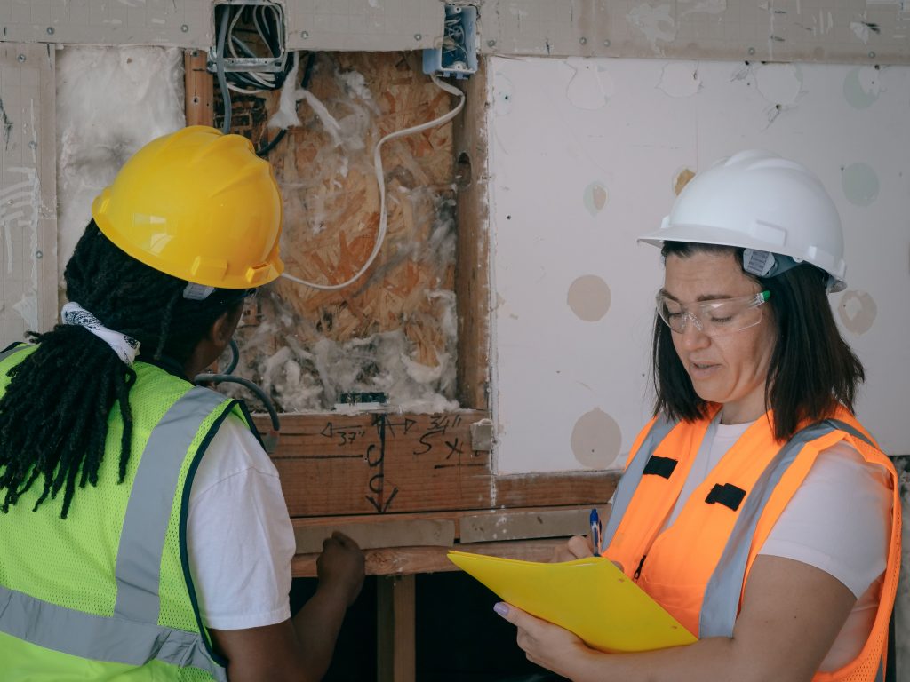 Inspectors checking wall cavities during a pre-demolition asbestos assessment in Queensland.